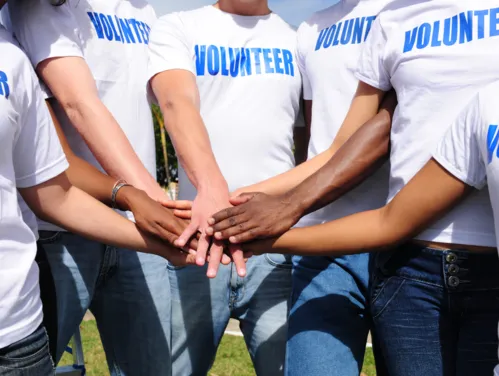 Volunteers with hands stacked for unity.