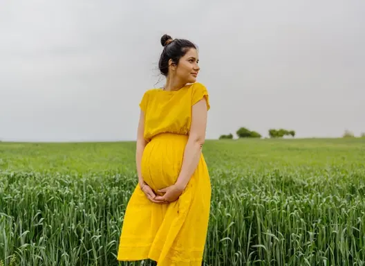 Pregnant mother standing in a field