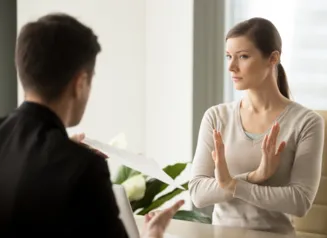 woman with crossed arms looking at a man