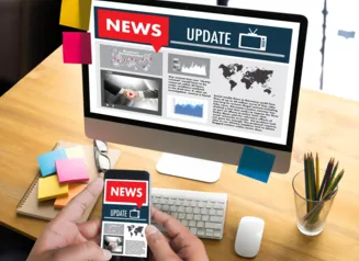 Laptop and smart phone with news items on the screen.