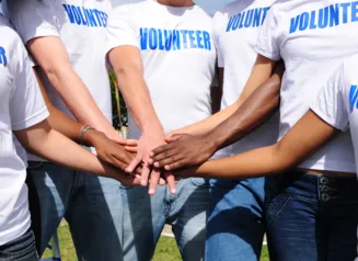 Volunteers with hands stacked for unity.